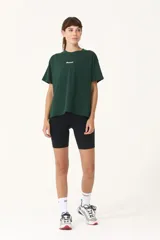 Remera verde con cuello redondo y manga corta. Estampado frontal con la palabra "Basset" en color blanco.