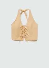 Top corto de cuello halter con cierre frontal mediante lazos decorativos. Presenta un diseño ajustado y sin mangas, confeccionado en una mezcla de fibras naturales.