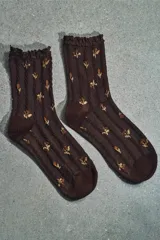 Calcetines marrones con estampado de flores en tonos naranja y beige, confeccionados en hilatura de algodón. Presentan un detalle de tejido con estructura y acabado con puntilla a tono en el borde superior.