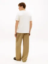 Remera de corte regular y cuello redondo de la marca Tommy Hilfiger, confeccionada en algodón de color blanco. Presenta un diseño gráfico en el pecho con el logo NYC y un pequeño logo bordado en la manga.