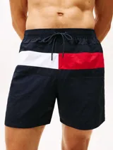 Short de baño Tommy Hilfiger de corte amplio, confeccionado en nailon. Presenta un diseño color block en la parte frontal con los colores distintivos de la marca, cintura elástica con cordón ajustable, dos bolsillos laterales y un bolsillo trasero de ojal.