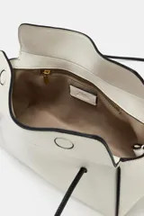 Bolso de hombro de diseño alargado en color blanco con detalles de bordes y asas largas en color negro. Cuenta con cierre imantado y bolsillo interior con cremallera.