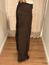 Pantalon de corte ancho y holgado, confeccionado en una mezcla de algodón, viscosa y lino. Presenta un diseño fluido con pinzas debajo de la rodilla, pespuntes en contraste y bordado de monograma en el bolsillo delantero.