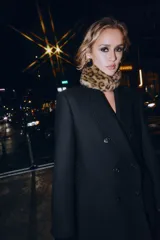 Cuello de pelo sintético con estampado animal print, presenta un diseño rectangular con cierre mediante una lazada de cinta de terciopelo negro en el centro.