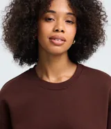 Buzo femenino de cuello redondo y manga larga, confeccionado en tejido de algodón con felpa. Presenta un diseño básico sin estampado, con puños y ruedo ajustados en tejido rib.