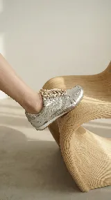 Zapatilla de cuero con diseño minimalista, cordones al tono y detalles de costuras laterales. Cuenta con suela plana y estructura ligera.