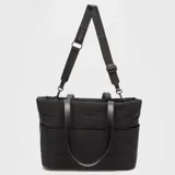 Bolso tote Bubba modelo Pair Travel, color negro, confeccionado en nylon resistente y liviano con diseño acolchado. Cuenta con asas de mano fijas de cuero sintético y una correa larga ajustable con el logo de la marca estampado. Incluye bolsillos laterales y cierre superior.