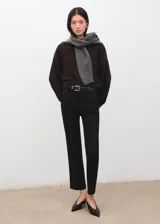 Pantalón negro de corte recto y tiro medio, con trabillas para cinturón.