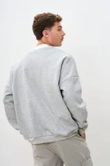 Buzo gris con estampa en el frente con el texto "Brooklyn New York" en color bordó.