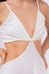 Vestido largo blanco con escote en V, abertura en la cintura y breteles finos.