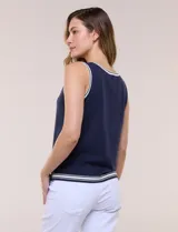 Musculosa de tejido de punto color azul marino, de corte recto, con cuello redondo y sisa amplia. Presenta detalles de líneas en contraste de color blanco en el cuello, las sisas y el ruedo.