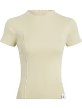 Sweater de punto canalé color crema, ajustado al cuerpo, con cuello mock y mangas cortas. Presenta costuras visibles que definen la silueta y un pequeño bolsillo decorativo en el pecho. Incluye una etiqueta con el logo 'CK' en el bajo.