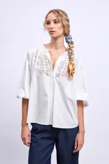 Camisa blanca de mangas 3/4 con detalle de encaje en el frente.