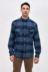 Sobrecamisa de algodón con diseño a cuadros en tonos azules, cuello clásico, cierre frontal con botones y dos bolsillos en el pecho con solapa.