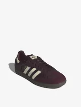 Championes Adidas Samba OG de caña baja, con diseño clásico de puntera en forma de T y tres bandas laterales dentadas. Presenta un empeine de cuero con estampado texturizado en color bordó y detalles en crema, sobre una suela de goma oscura.