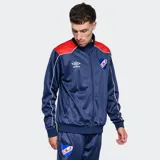 Conjunto deportivo Umbro del Club Nacional de Football, compuesto por una campera con cierre frontal y pantalón de jogging a juego. La campera es azul con detalles en rojo en los hombros y el logo de Umbro y el escudo del club en el pecho. El pantalón es azul con el escudo del club en el muslo.