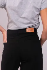 Pantalón de corte wide leg confeccionado en pana acanalada color marrón chocolate. Presenta tiro alto, cierre frontal con botón y bolsillos laterales.