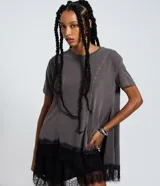 Remera verde militar de algodón con efecto desteñido, cuello redondo, mangas cortas, recortes asimétricos y detalle de encaje negro en el bajo irregular.