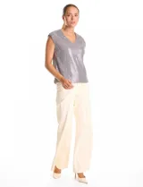 Blusa sin mangas con escote en V, confeccionada completamente en lentejuelas color dorado. Cuenta con forro interno a tono y un corte recto y holgado.