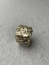 Anillo de diseño escultural y texturado, con acabado rugoso que simula una superficie montañosa o corteza.