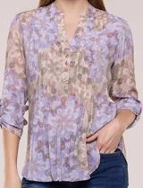 Blusa de gasa estampada de la marca Zac & Rachel, en tonos violeta y marrón. Presenta cuello a la base con escote en V y botones frontales, detalles de plisado en la delantera y mangas largas con sistema para regular su largo mediante presilla y botón.