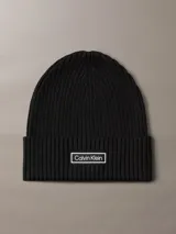 Gorro tipo beanie de punto grueso acanalado en color negro, con vuelta y parche rectangular con el logo de Calvin Klein en el frente.