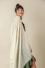 Chal de tejido ligero con acabado brillante en tono plateado y terminación de flecos en los extremos.