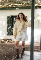 Camisa de manga larga con diseño abullonado, confeccionada en tela bordada con motivos florales. Presenta cierre frontal con botones y puños elásticos.
