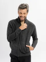 Campera tejida de punto en color beige, con diseño de trenzas y rombos, cuello alto y cierre frontal completo.