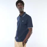 Remera polo de piqué color azul marino con detalles blancos en el cuello y los puños, cierre frontal con botones y pequeño logo bordado en el pecho.
