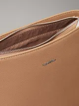 Cartera tipo saco color tostado de cuero sintético granulado, con correa de hombro ajustable de cuero sintético y correa bandolera ajustable de jacquard con logo.