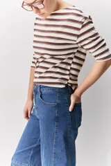 Jean de corte barrel, tiro alto, con silueta amplia que se estrecha hacia el tobillo. Confeccionado en denim azul oscuro con costuras a contratono.
