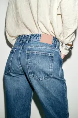 Jeans de tiro bajo color azul, con cinco bolsillos y pernera recta y larga. Cierre frontal con cremallera y botón.