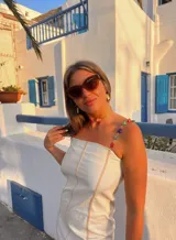 Vestido corto blanco de lino con tirantes finos adornados con piedras de colores.