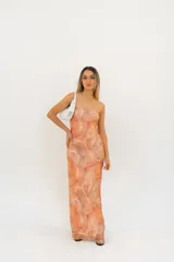 Vestido largo sin mangas, con escote palabra de honor y un estampado tipo batik en tonos naranjas y beige.
