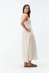 Vestido midi negro con escote cuadrado, tirantes anchos y falda de corte acampanado.