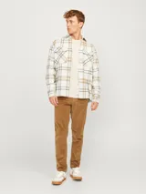 Sobrecamisa a cuadros color crema, marrón y blanco, de manga larga con cierre de botones y bolsillos en el pecho.