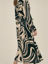 Vestido largo estilo camisero confeccionado en seda viscosa con estampado abstracto en blanco y negro. Cuenta con botones nacarados, bolsillos laterales, lazo para ajustar en la cintura y aberturas laterales.
