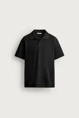 Polo de punto negro de corte regular fit, con cuello solapa, abertura frontal en V y mangas cortas. Presenta textura acanalada vertical y acabados en rib.