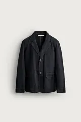 Blazer relaxed fit de algodón color negro, con cuello de solapas de muesca, bolsillos de parche con solapa en la cadera y cierre frontal de dos botones.