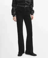 Jeans negros de corte flare, tiro medio y diseño clásico con bolsillos.