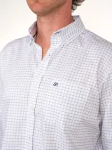 Camisa de corte clásico con estampado de cuadros en tonos rosados y celestes, con cuello abotonado, manga larga y bolsillo frontal con detalle bordado.
