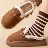 Pantuflas de gamuza color marrón para mujer, estilo zueco sin talón, con plataforma baja, forro interno de corderito sintético blanco, ribete de corderito en el cuello y detalle de tira lateral con hebilla metálica.