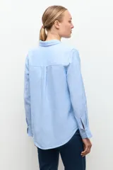 Camisa de lino color celeste melange, de corte clásico con cuello camisero y manga larga.