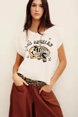 Remera blanca de algodón con cuello redondo, mangas cortas con vuelta y estampa frontal de un tigre con la inscripción 'Los Angeles' y estrellas.