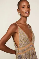 Vestido largo de viscosa con estampado floral, tirantes finos, escote en V y detalle de encaje en el busto. Cuenta con una silueta fluida y una abertura frontal en la falda.