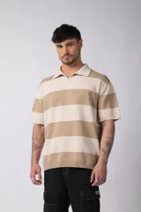 Remera tipo chomba de tejido de punto con diseño de rayas horizontales anchas en tonos beige y crema. Presenta cuello polo con escote en V, mangas cortas y un corte holgado oversize.