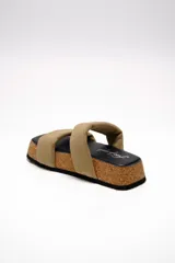 Sandalias planas Free People modelo Fairmount Flared, con plataforma de corcho acampanada, plantilla negra y dos tiras acolchadas anchas de cuero color beige.