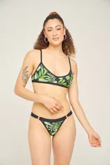 Corpiño de bikini con estampado geométrico en tonos lila, verde y blanco, con breteles finos cruzados en la espalda.