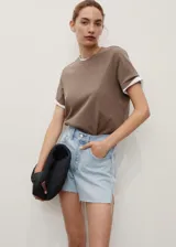 Short de denim celeste claro, con tiro medio, diseño de cinco bolsillos, presillas para cinturón y bajo deshilachado con pequeña abertura lateral.